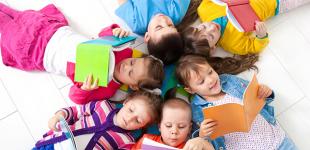 La imagen muestra un grupo de niños y niñas mirando libros