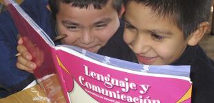 La imagen muestra a 2 niños leyendo el libro de lenguaje y comunicación