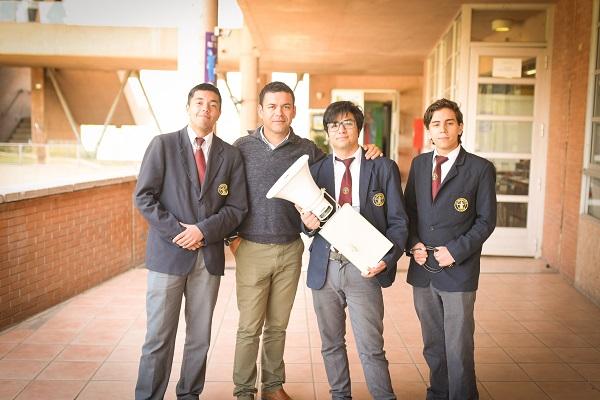 Claudio Sáez junto a tres estudiantes de 4° medio y la alarma barrial.